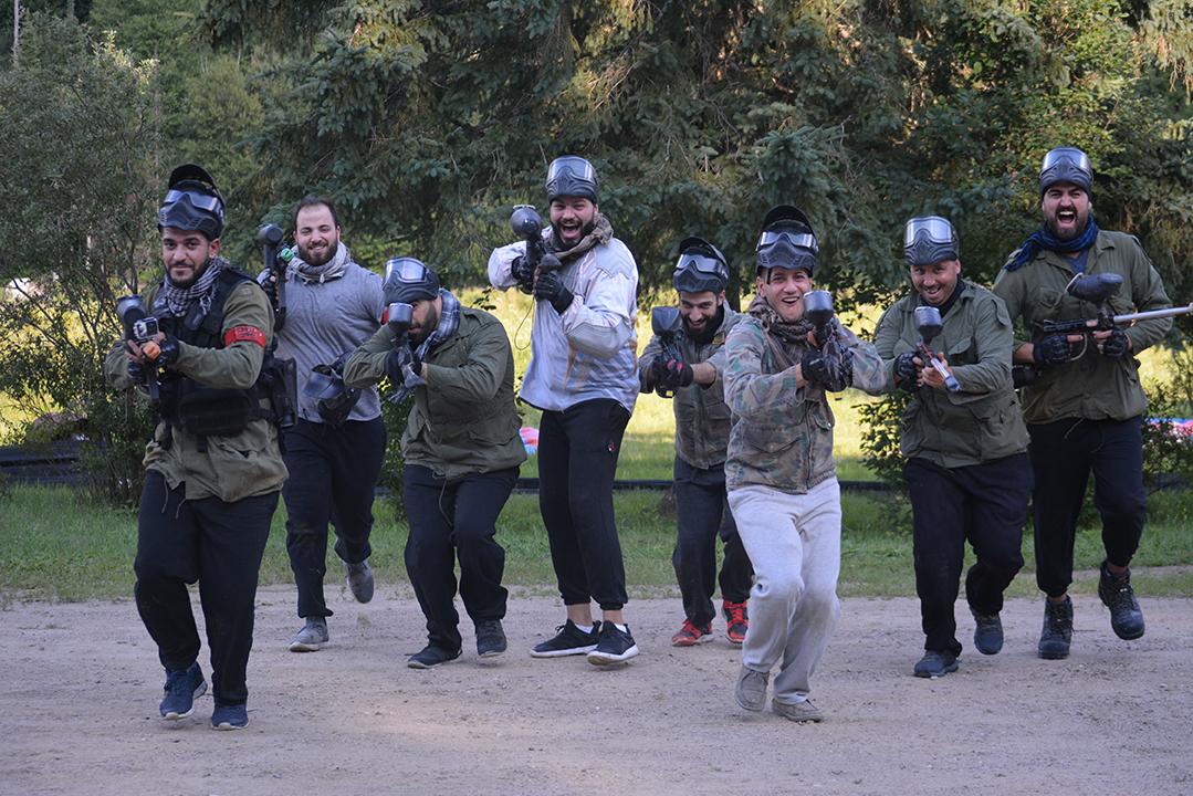 Friends running into an outdoor paintball mission at Fort Ouest near Mont-Tremblant