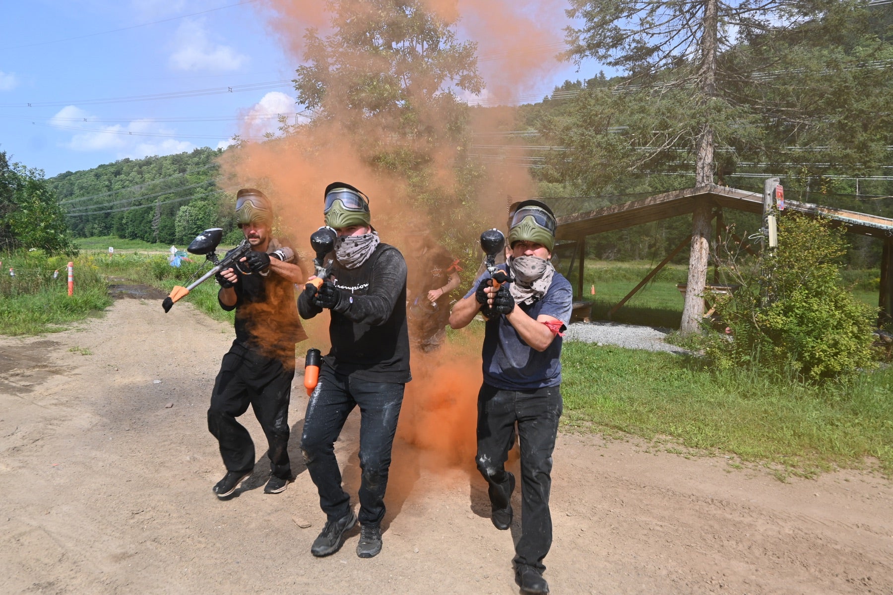 Paintball players in action with colourful smoke