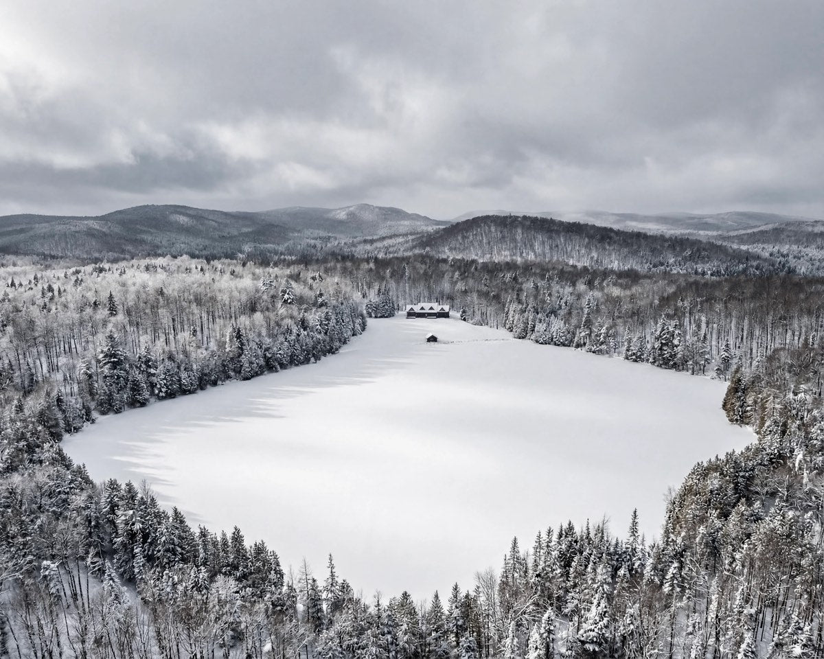Vue aérienne hivernale de Méchante Cabane et de son lac privé